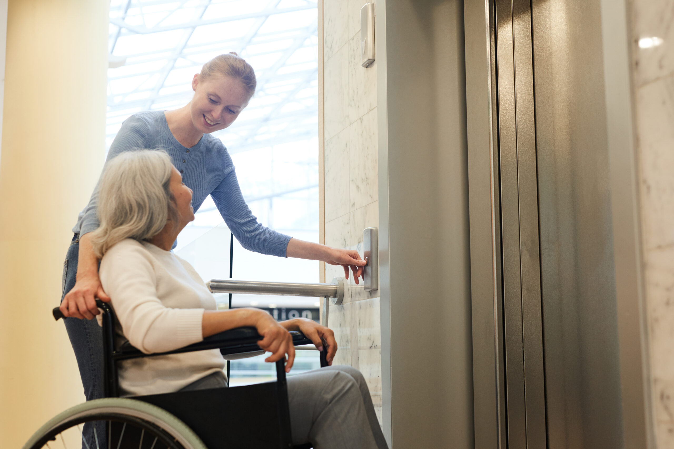 Infirmière avec femme utilisant l'ascenseur